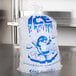 A clear plastic bag of ice with blue "Ice" print and a penguin.