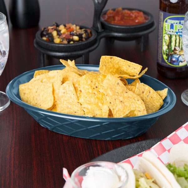 A blue polyethylene oval weave basket filled with chips on a table.