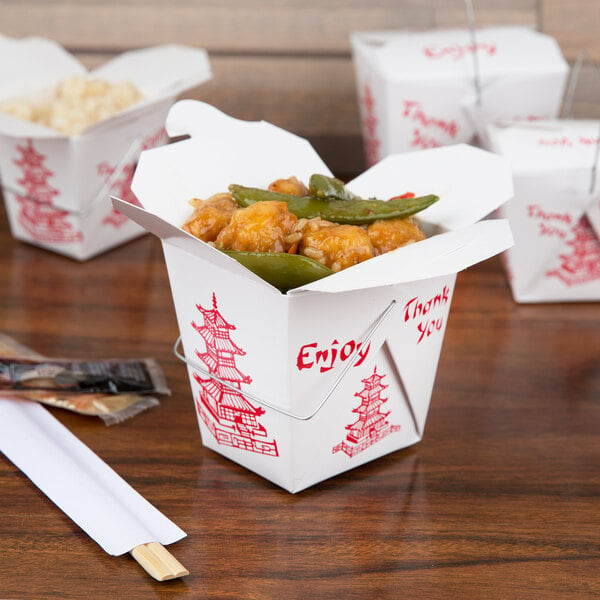 A group of Fold-Pak Pagoda Chinese take-out boxes with food on a table.