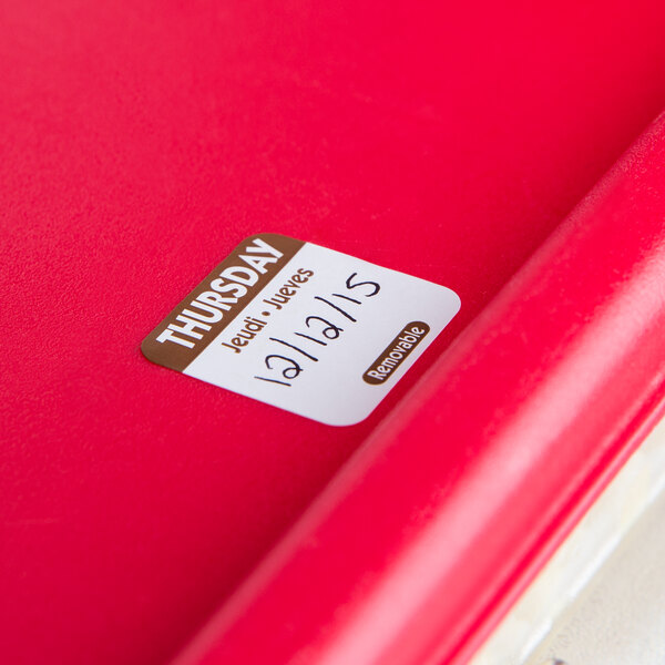 A red notebook with a National Checking Company Thursday food labeling sticker on it.