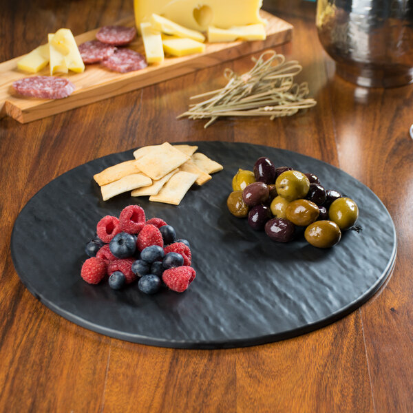 A Tablecraft Frostone faux slate melamine tray with fruit and cheese on it.