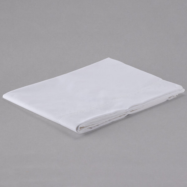 A folded white Oxford T200 Superblend pillow case on a gray surface.