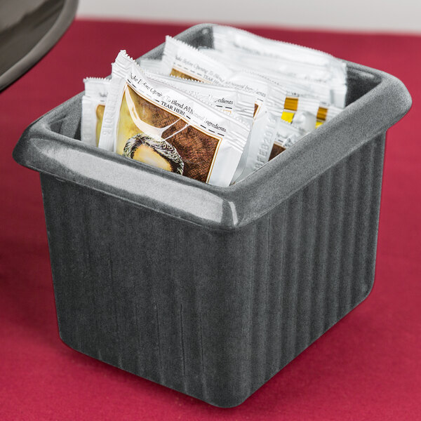 A Tablecraft granite rectangle server with tea packets in it on a hotel buffet counter.