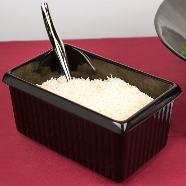 A black rectangular Tablecraft server with white food and a spoon.