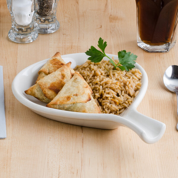 A Tuxton eggshell china fry pan server with brown rice on a table.