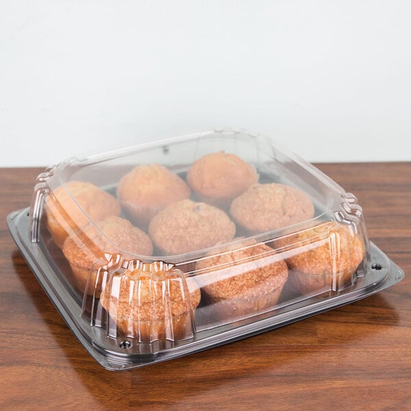 A Sabert plastic container with a high dome lid holding food.