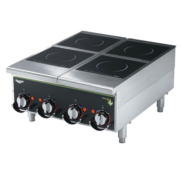A black Vollrath countertop induction hot plate with four burners on a counter.