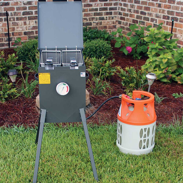 A grey R & V Works outdoor deep fryer with legs.