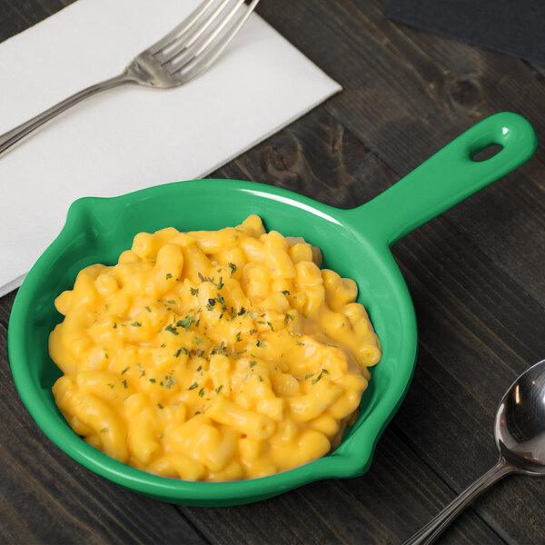 A Tablecraft green cast aluminum fry pan filled with macaroni and cheese on a table.