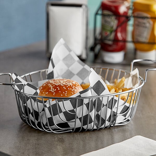 A table with a basket of food wrapped in black and white checkered paper.