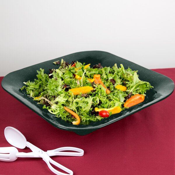 A Tablecraft hunter green square bowl filled with salad with a white speckled pattern.