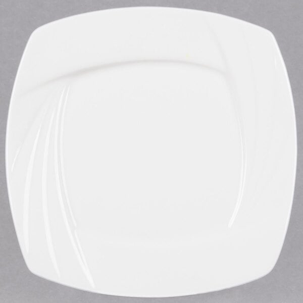A close-up of a CAC white square porcelain plate with a curved edge.