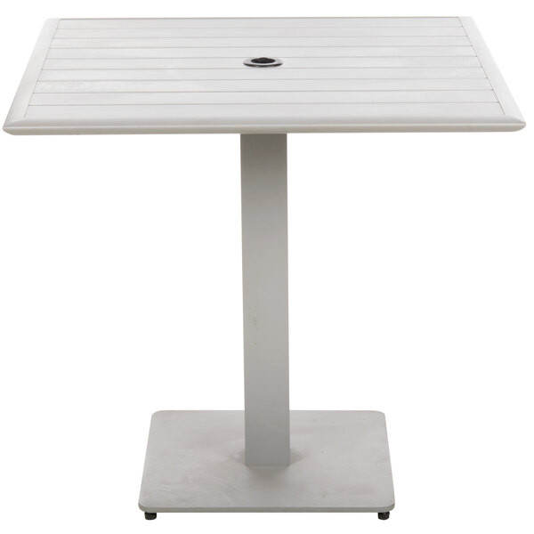 A white square table with a metal base and a hole in the center.