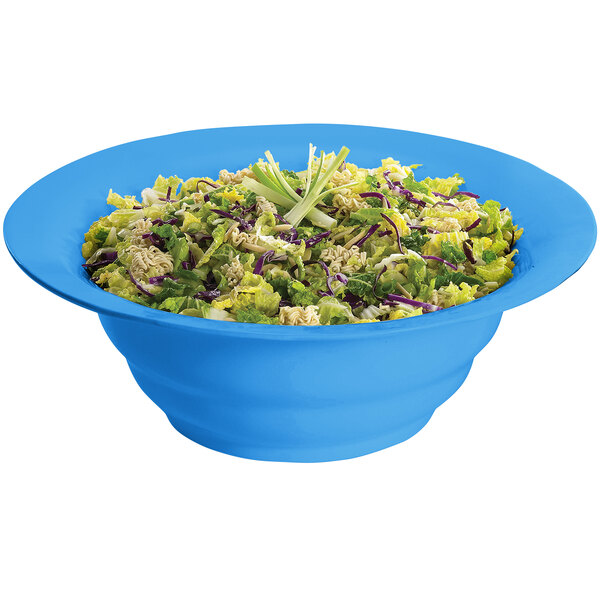 A Tablecraft sky blue cast aluminum salad bowl filled with salad on a white background.