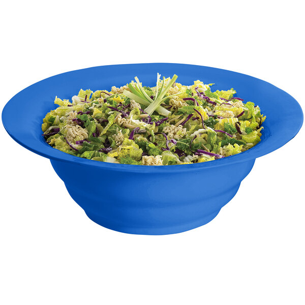 A Tablecraft cobalt blue cast aluminum salad bowl filled with salad.