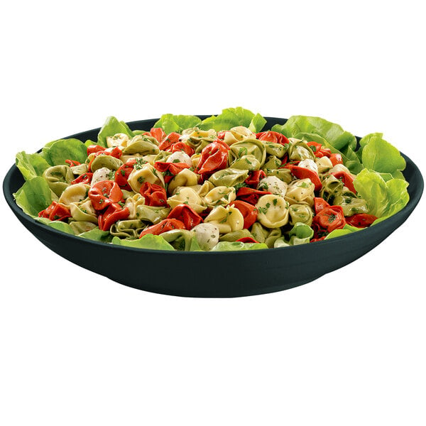 A Tablecraft black cast aluminum pasta bowl with lettuce and tortellini.