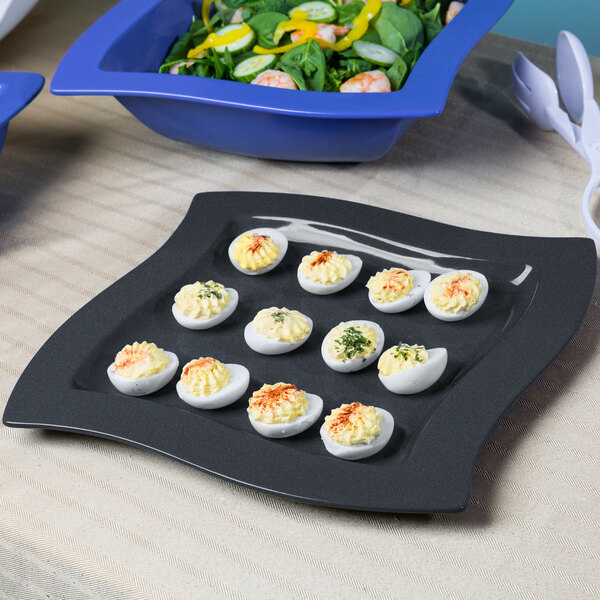 A Tablecraft square metal platter with deviled eggs and salad.