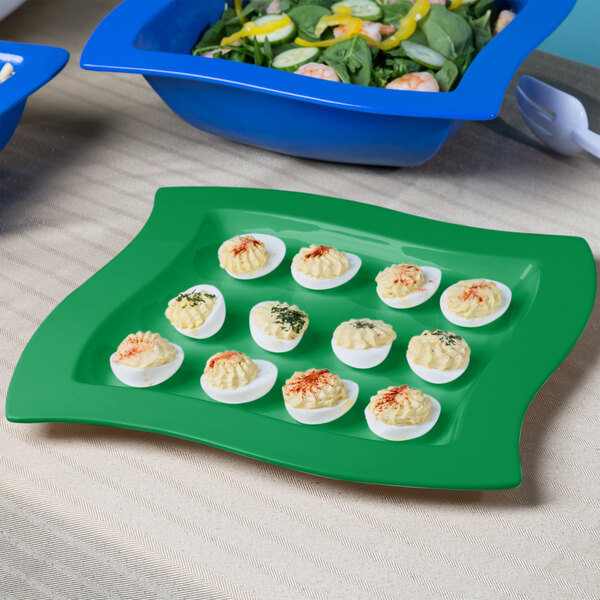 A Tablecraft green cast aluminum platter with deviled eggs and salad.