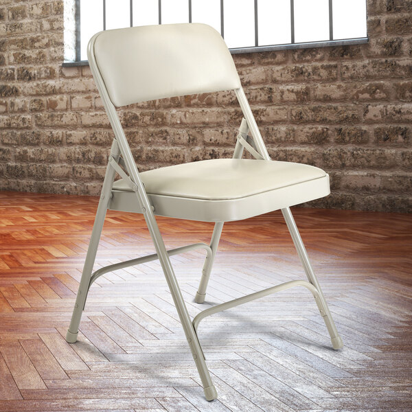 A gray National Public Seating metal folding chair with a warm gray padded seat.