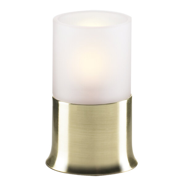 A white candle in a gold base with a white glass frost globe over it.
