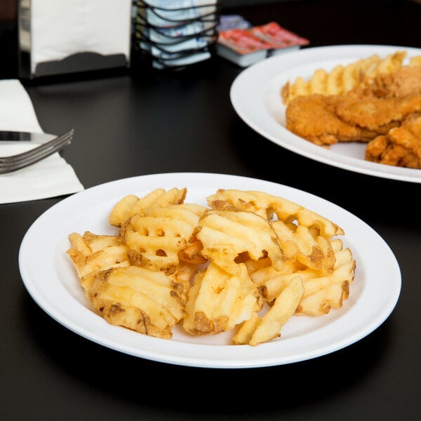 A white Thunder Group Nustone melamine plate with french fries and chicken.