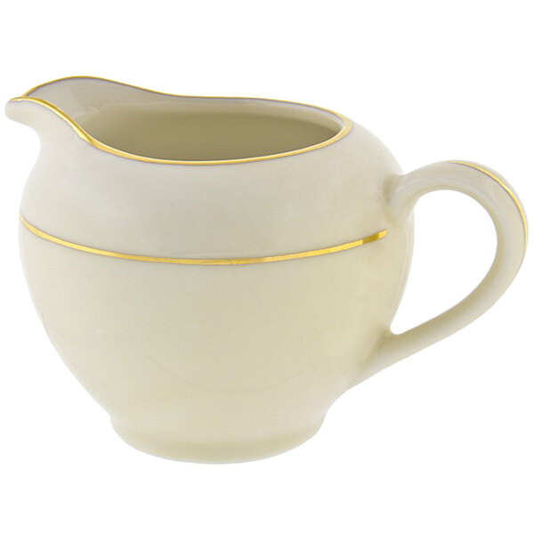 A white porcelain creamer with a gold stripe along the rim.