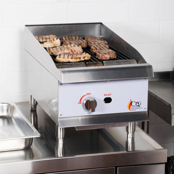 A Cooking Performance Group gas countertop charbroiler with meat on it.