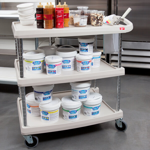 A gray Metro utility cart with containers of food on it.
