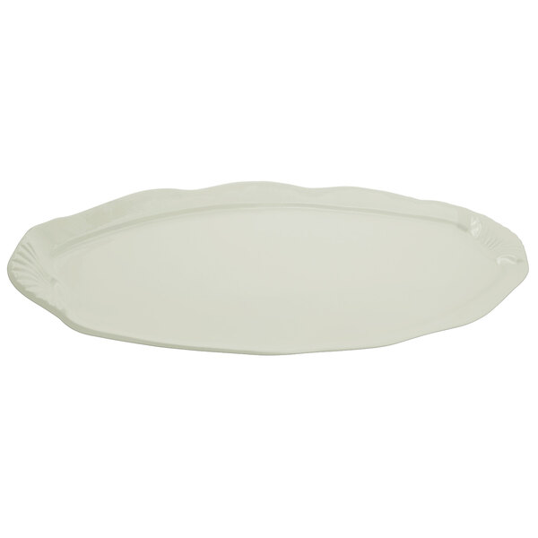 A white oval cast aluminum platter with a scalloped edge and shell and fish design.