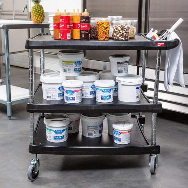 A black Metro utility cart with three shelves holding food and other items.