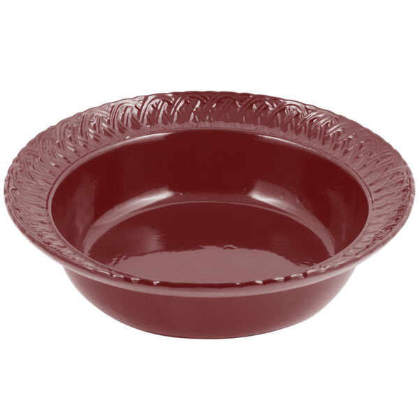 A red Bon Chef cast aluminum bowl with a decorative edge.