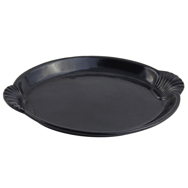 A black cast aluminum platter with a scalloped edge shaped like a shell and fish.