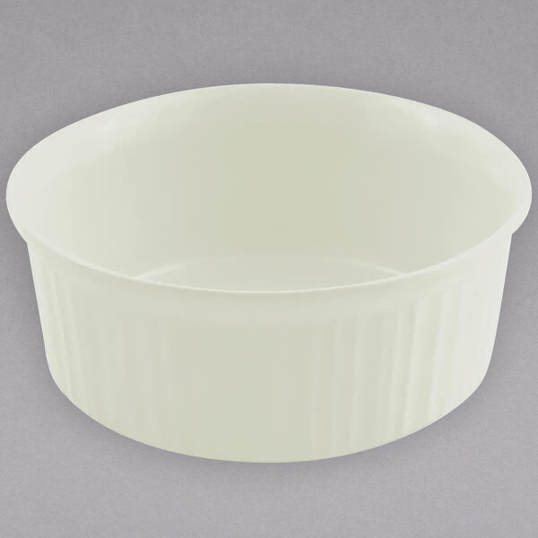 A Bon Chef ivory cast aluminum round casserole dish with a ribbed rim on a gray surface.