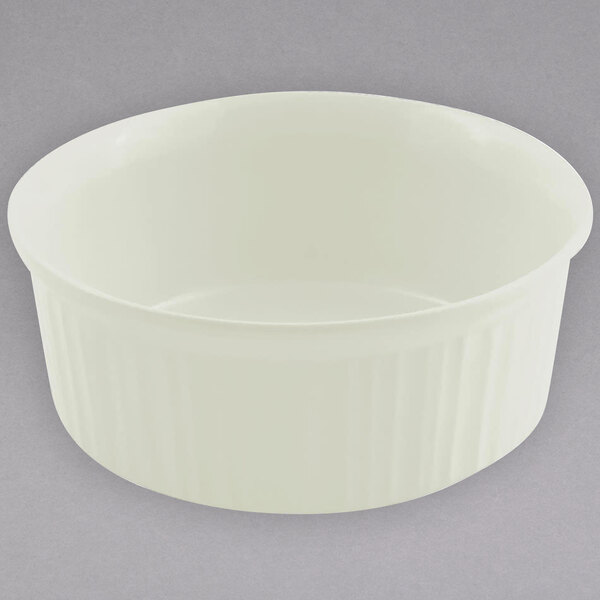 A white Bon Chef cast aluminum casserole dish with a ribbed rim on a gray surface.