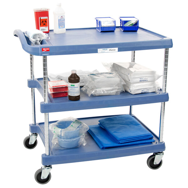 A blue Metro utility cart with three shelves holding medical supplies.