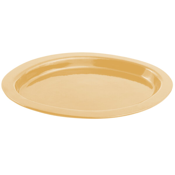 A Bon Chef ginger sandstone finish oval casserole dish on a yellow surface.