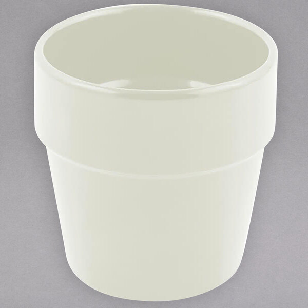 A white round container with a lid on a gray surface.