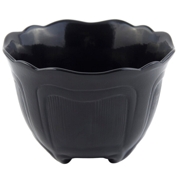 A black bowl with a scalloped edge and a small handle.