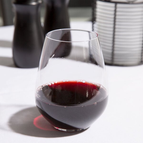 A Spiegelau Authentis stemless red wine glass filled with red wine on a table.