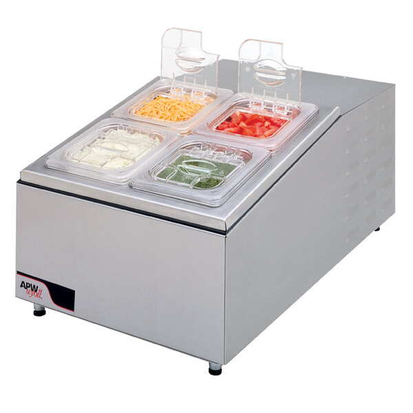 An APW Wyott refrigerated countertop topping rail with four compartments on a counter filled with food trays with different toppings.
