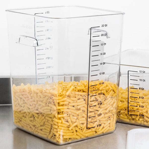 A large Rubbermaid clear plastic container filled with pasta on a counter.