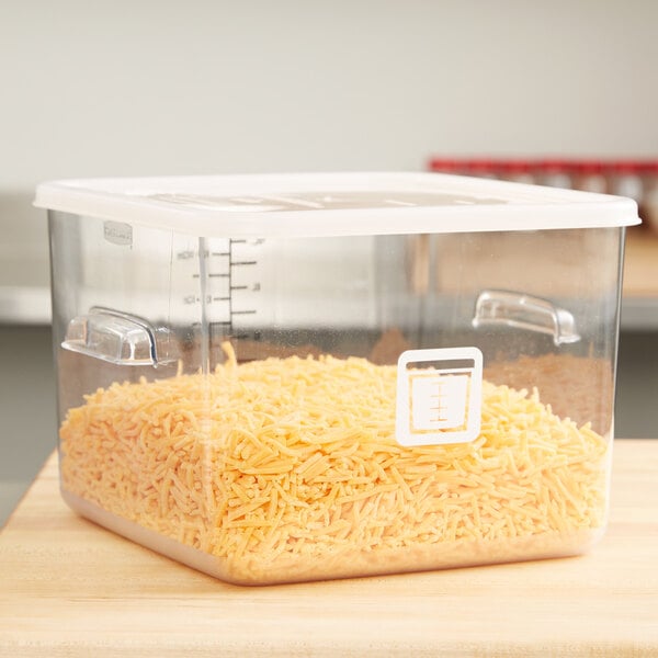 A Rubbermaid white square polyethylene food storage container lid on a large plastic container with shredded cheese in it.