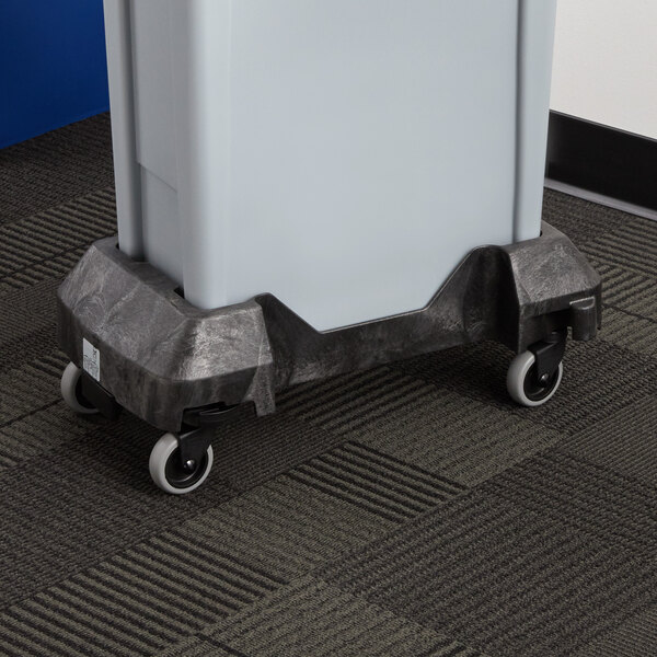 A black Rubbermaid Slim Jim dolly with a gray trash can on it.