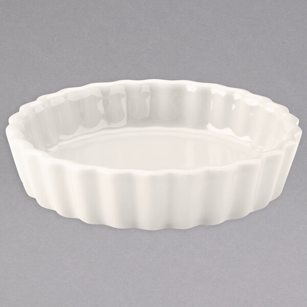 A Hall China ivory fluted souffle dish with a scalloped edge.