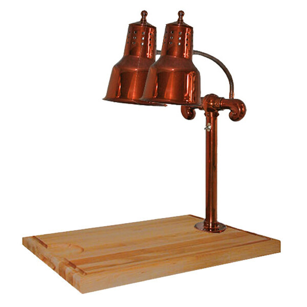 A Hanson Heat Lamps smoked copper carving station with maple block and gravy lane under copper lamps on a wooden surface.