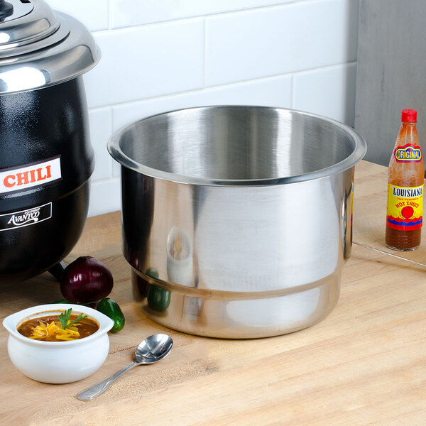 An Avantco stainless steel pot with a lid and a spoon on a counter.