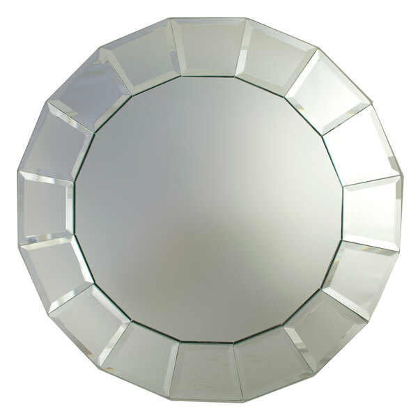 A close up of a round mirror with a circular design.