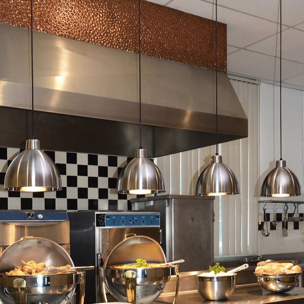 A Hanson stainless steel ceiling mount heat lamp above food in a metal container on a kitchen counter.