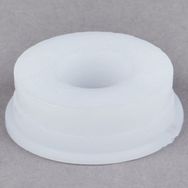 A white round plastic bearing with a hole in it.