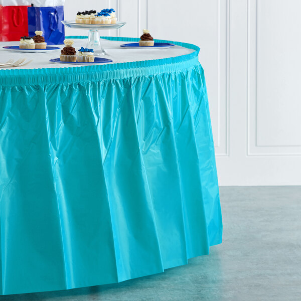 A table with a Bermuda Blue plastic table skirt on it.